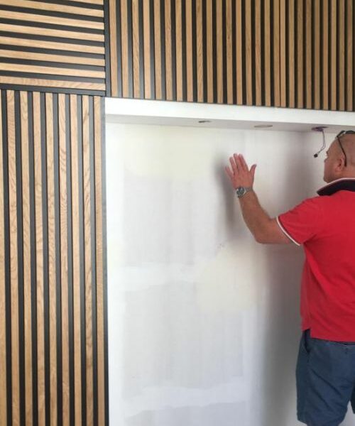 Artisan travaillant sur une cloison décorative en tasseaux bois