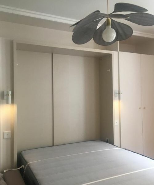 Chambre moderne avec mobilier intégré et éclairage mural