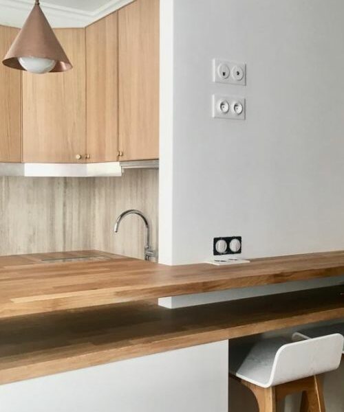 Cuisine ouverte avec bar en bois massif et mobilier clair