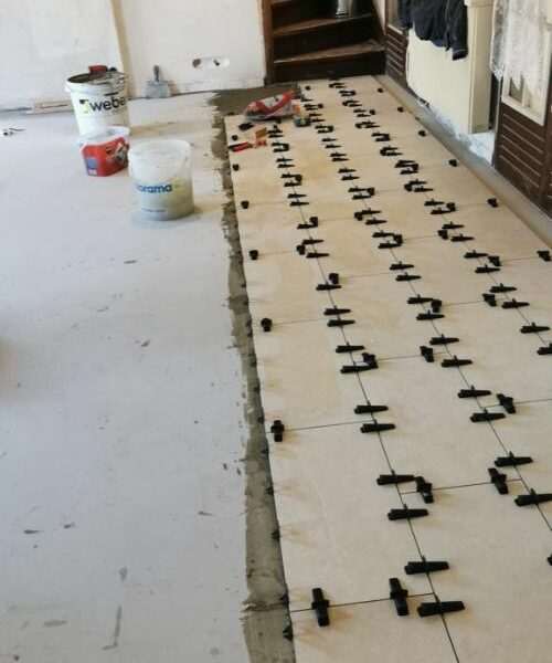 Travaux de carrelage en cours avec croisillons