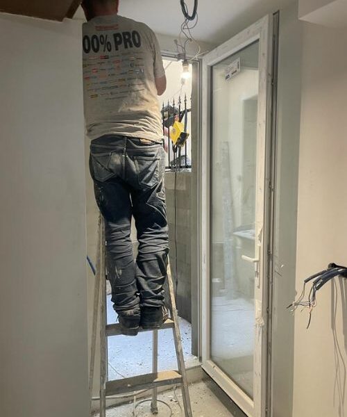 Électricien en intervention sur un plafond, installation de câblage.