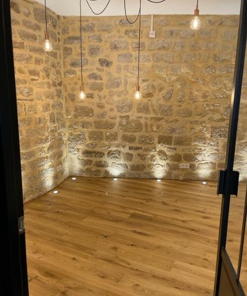 Mur en pierre apparente avec éclairage LED et ampoules suspendues