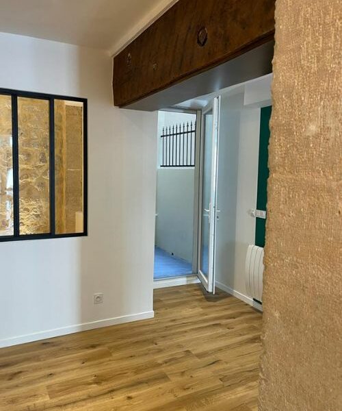 Pièce rénovée avec sol bois, verrière intérieure et accès extérieur