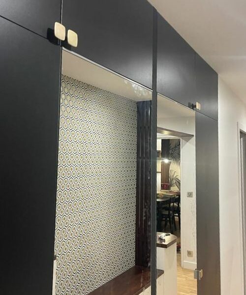Entrée avec panneaux noirs, banquette et miroir sur mesure