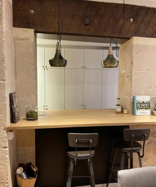 Bar en bois massif intégré entre deux murs de pierre