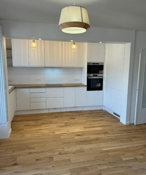 Vue d’ensemble d’une cuisine rénovée avec parquet bois