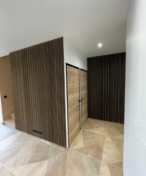 aménagement intérieur moderne avec portes bois et murs à lames verticales à Paris