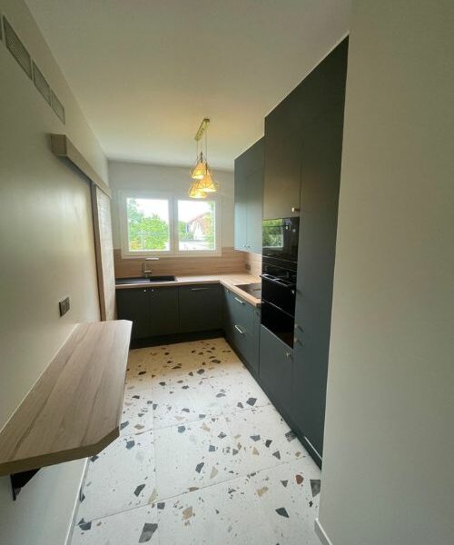 cuisine en L avec plan de travail bois et sol terrazzo à Paris