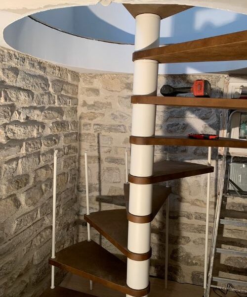 escalier hélicoïdal bois et métal dans un intérieur en pierre à Paris