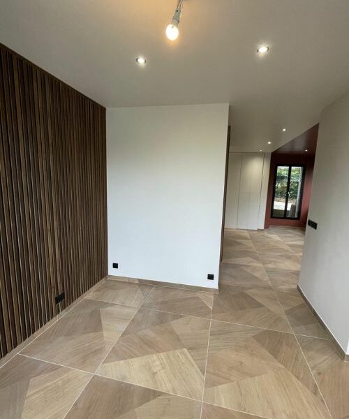 rénovation intérieure avec habillage mural en bois et sols clairs à Paris