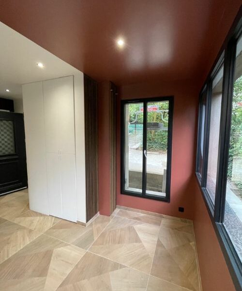 rénovation d’une entrée avec habillage mural bois et escalier moderne à Paris